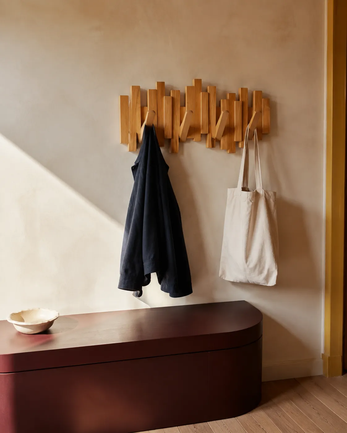 Inspiration : un porte-manteau en bois accueille une veste et un sac dans une entrée lumineuse